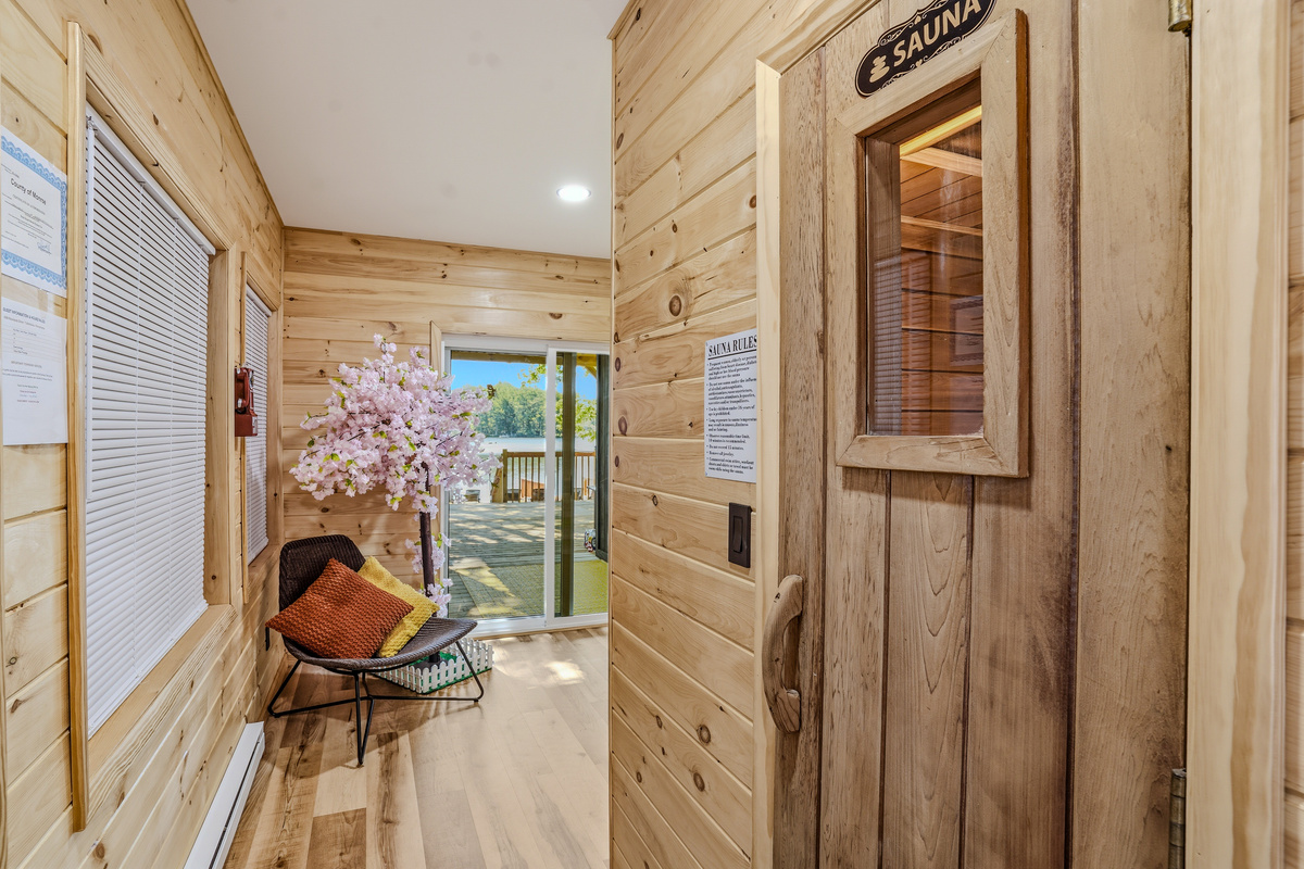 Lower-level entry hall with sauna sign, smart lock, and natural wood walls