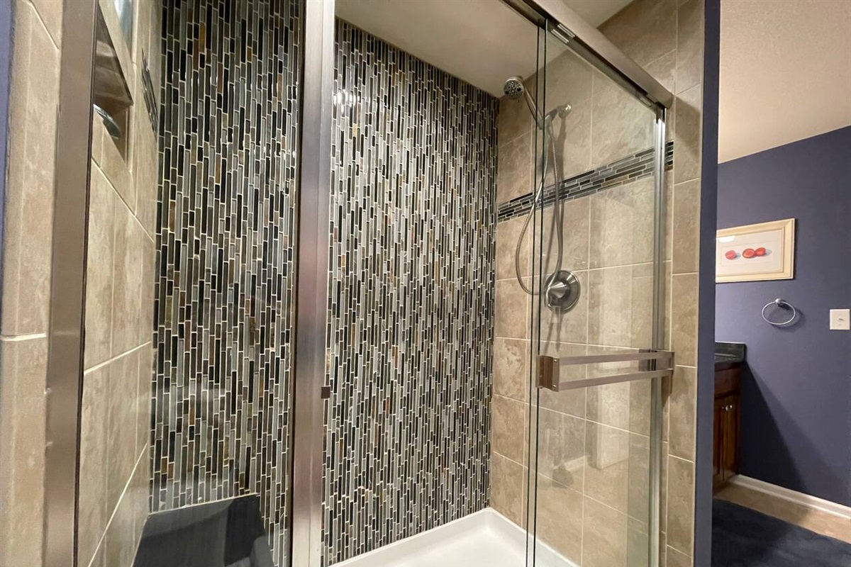 Bench seat in large walk in shower with removable handle shower head.