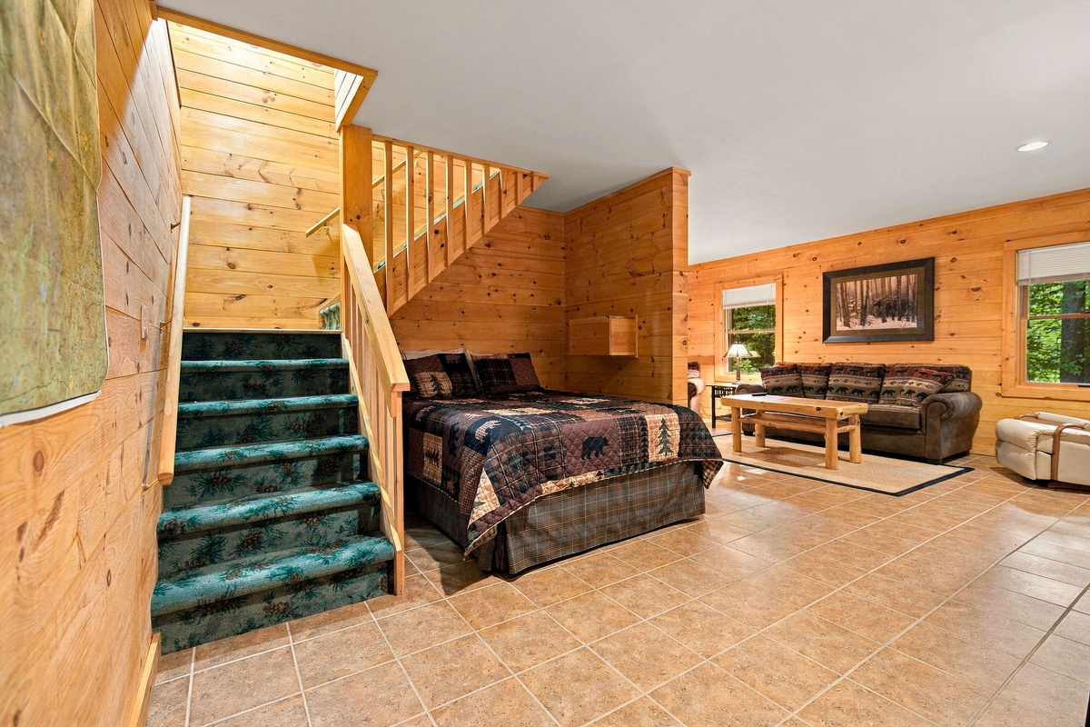 The open lower level offers additional sleeping space alongside the staircase.