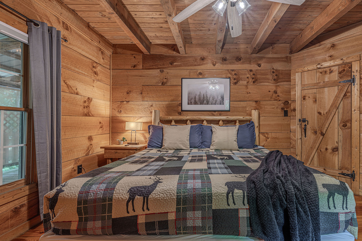 Plaid bedding, warm wood, and a sliding barn door.