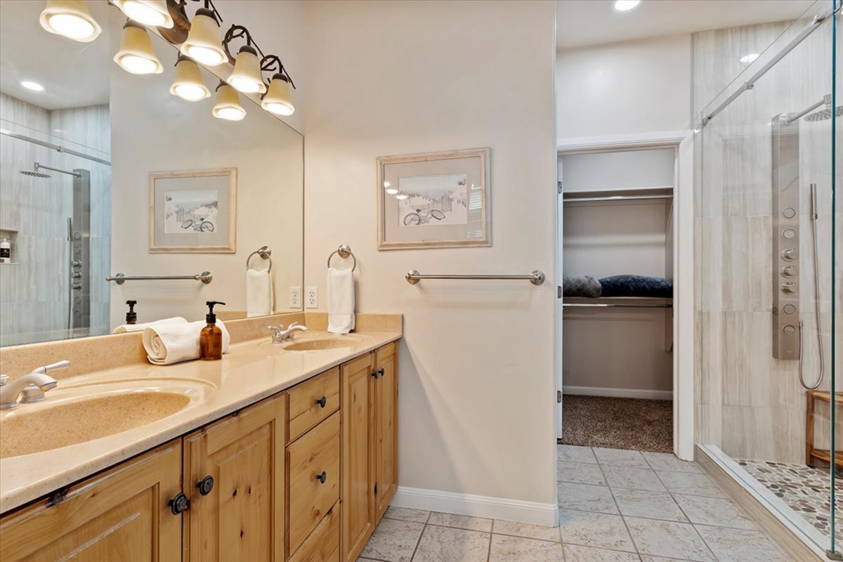 Refresh and recharge in the spacious primary bathroom offering a spa-like experience with dual vanities and generous space to get ready for the day.