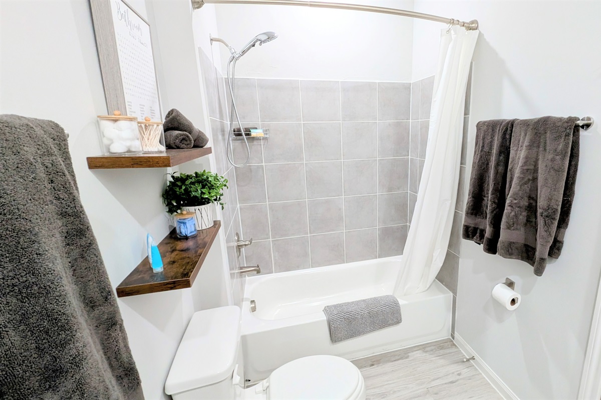 Full bath with tub/shower combo and plenty of fluffy towels.