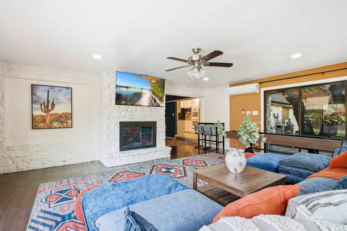 Living room with large Roku TV; kitchen located just behind