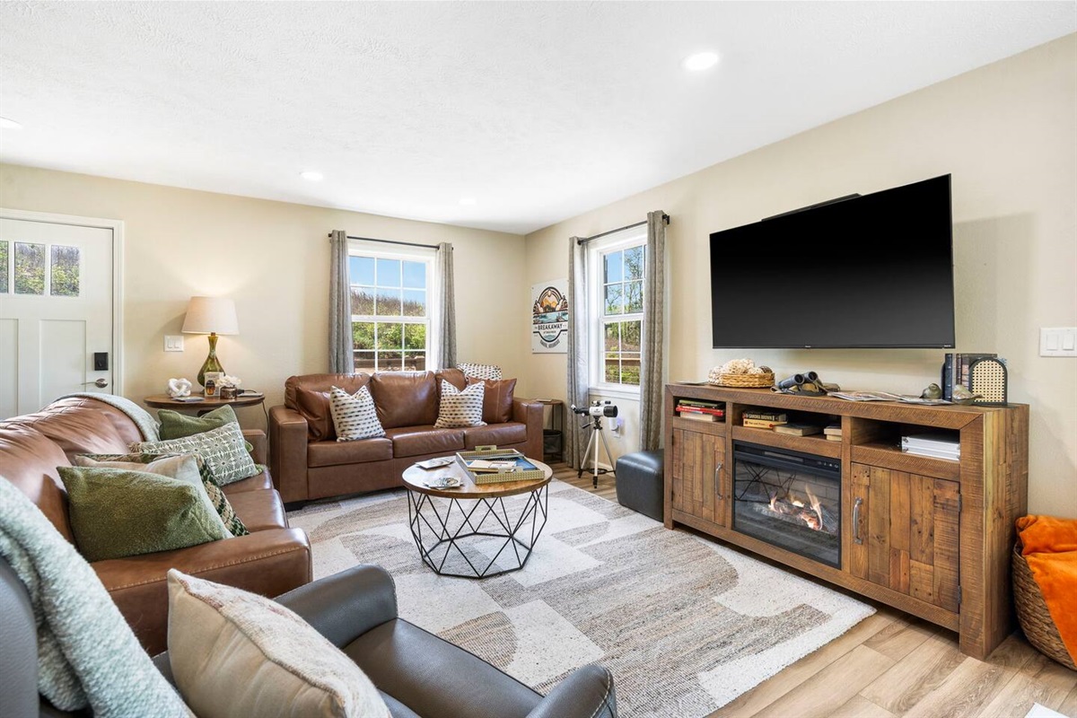 Open living room with comfy seating and a large TV.