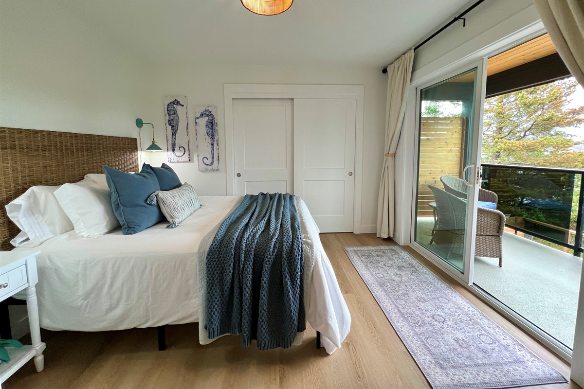 Villa A primary queen suite — plush bedding, private en-suite bath, and a walkout patio.
