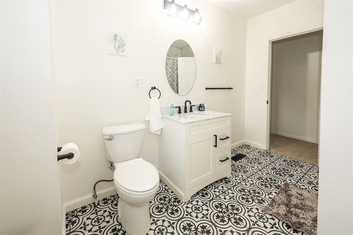 Enjoy a refreshing bath in this full bathroom with a sleek shower tub, designed with minimalist elegance for a calm and spacious feel.

