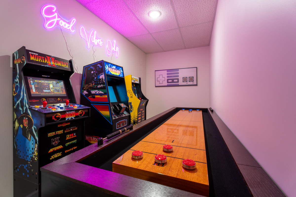 Full game room with arcade machines and a shuffleboard table. The kids will disappear in here. So will the adults!