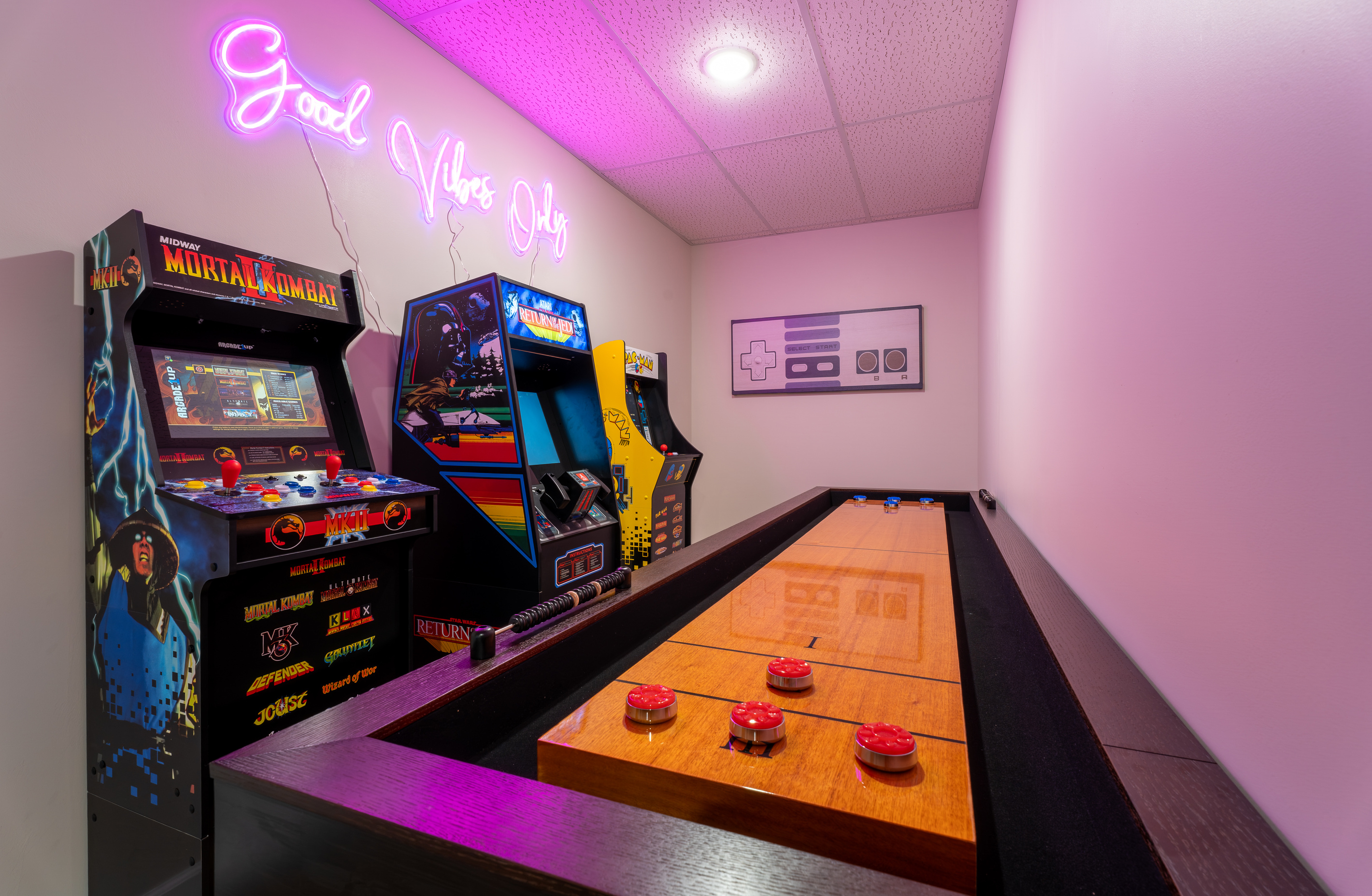 Full game room with arcade machines and a shuffleboard table. The kids will disappear in here. So will the adults!