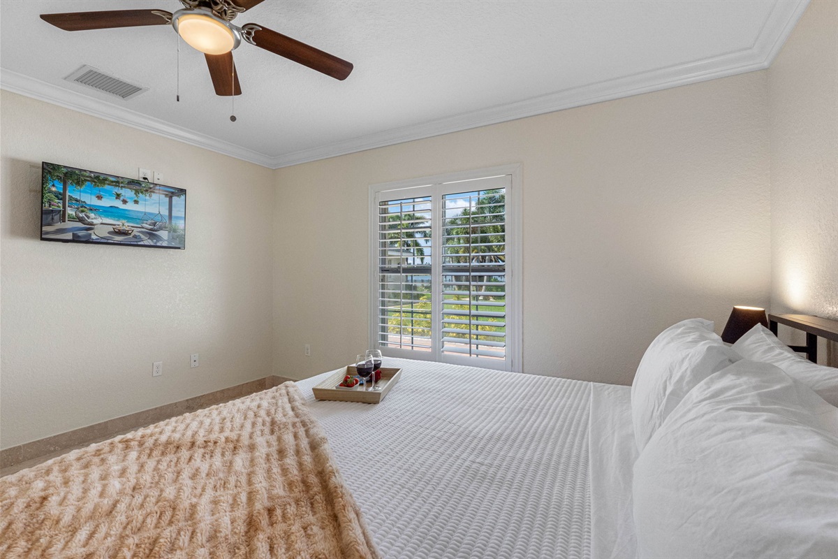 A large window with plantation shutters fills the room with light, enhancing its clean lines and simple elegance.