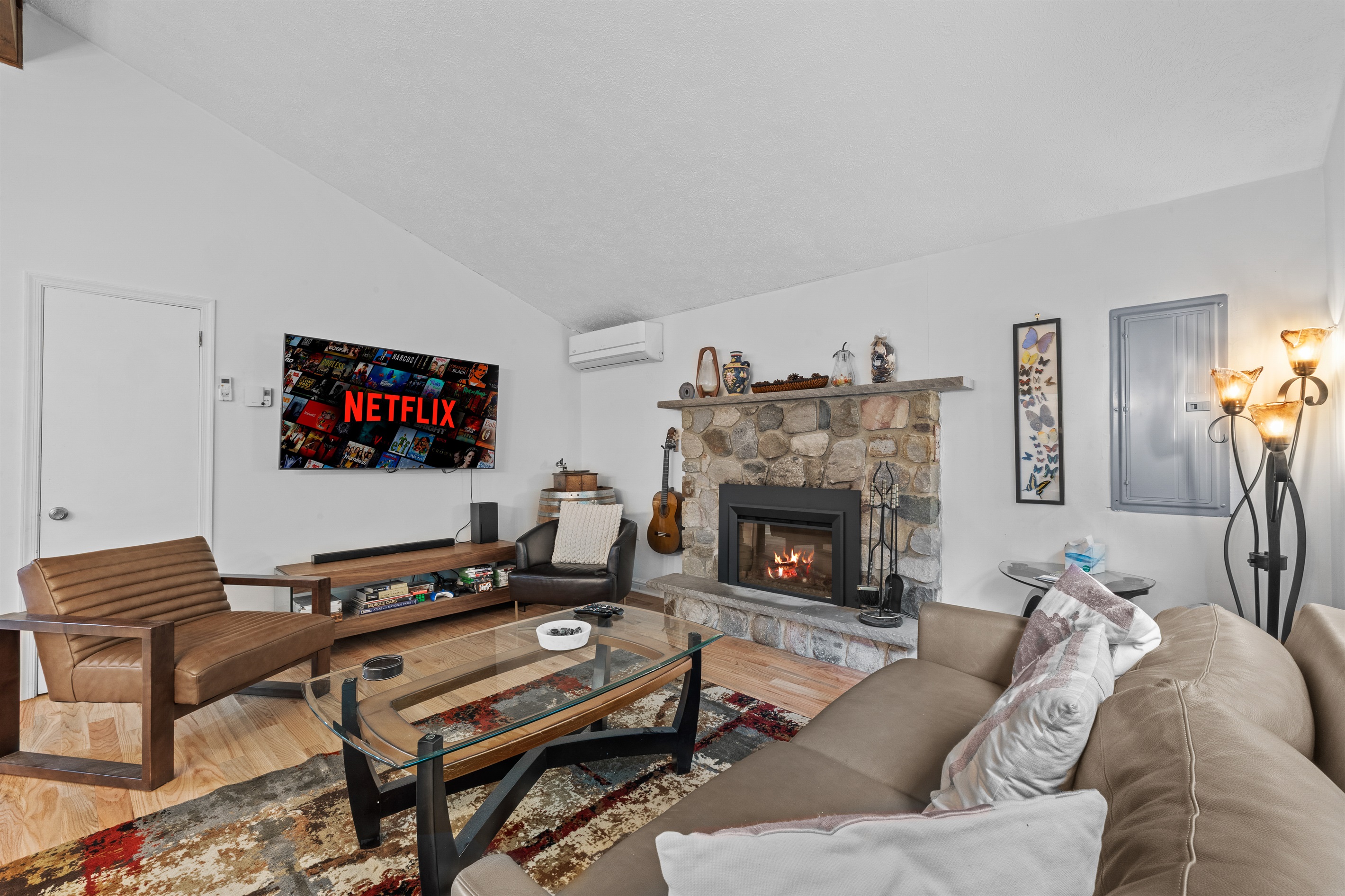Cozy living room with large TV, electric fireplace, and plush seating—perfect for movie nights