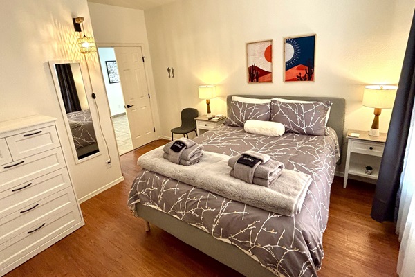 Queen bedroom downstairs with 55" smart Tv and blackout curtains