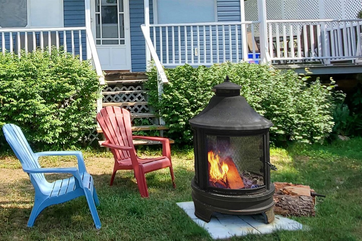 Front of Cozy 1 cottage with fire pit; cottage deck and BBQ area it to right of cottage