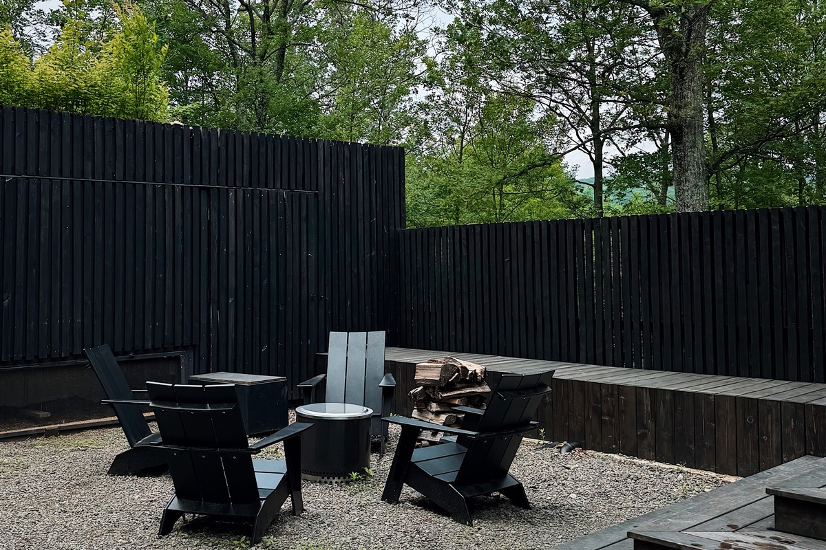 Fire pit in the dooryard with firewood and starters.
