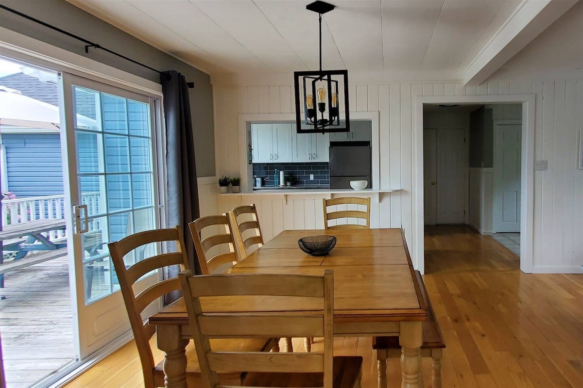 Grande Salle &agrave; manger - Dining area with view of kitchen and patio door access to deck
