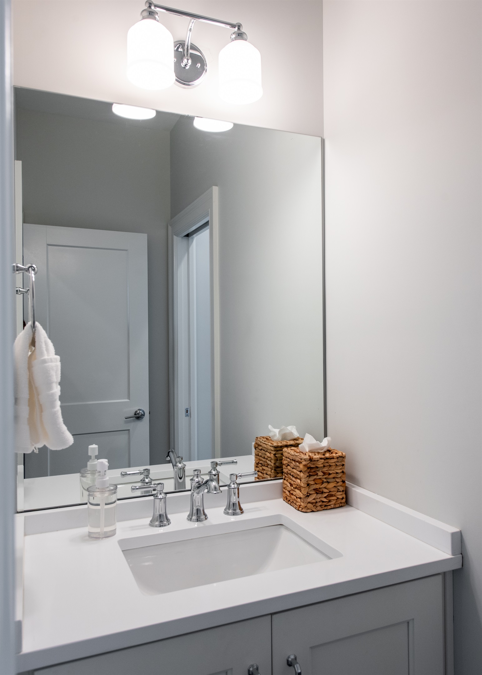Refresh in this sleek, contemporary bathroom featuring a well-lit vanity with ample counter space, chic wicker baskets, and soft towels. Perfect for unwinding after a day on the Bourbon Trail.