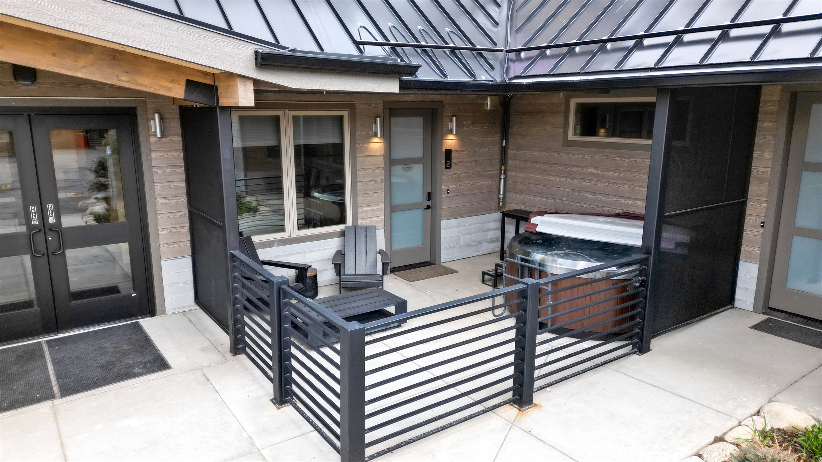 Private patio, hot tub, and property entrance