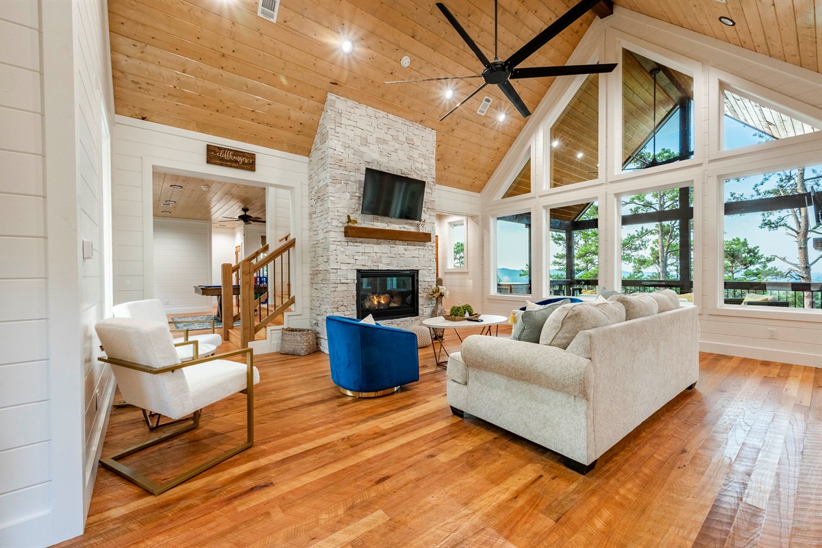 Spacious living room with vaulted ceilings, fireplace, and stunning natural light