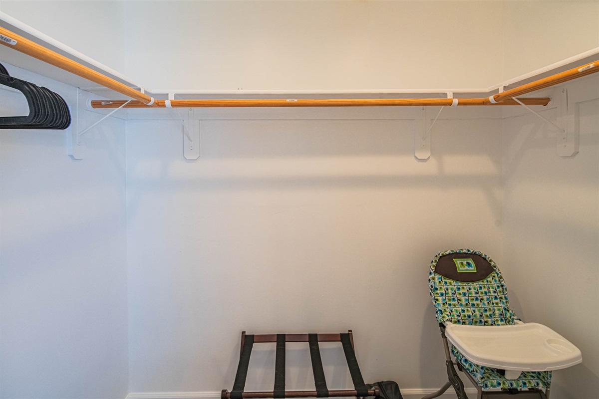 Primary closet offering hanging space and luggage rack, high chair, pack n play — ideal for longer stays, extended trips, or guests traveling with multiple bags.