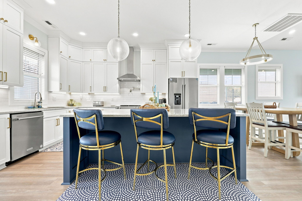 Create your favorite vacation meals in a modern kitchen featuring spacious countertops, stainless steel appliances, and a large island with seating