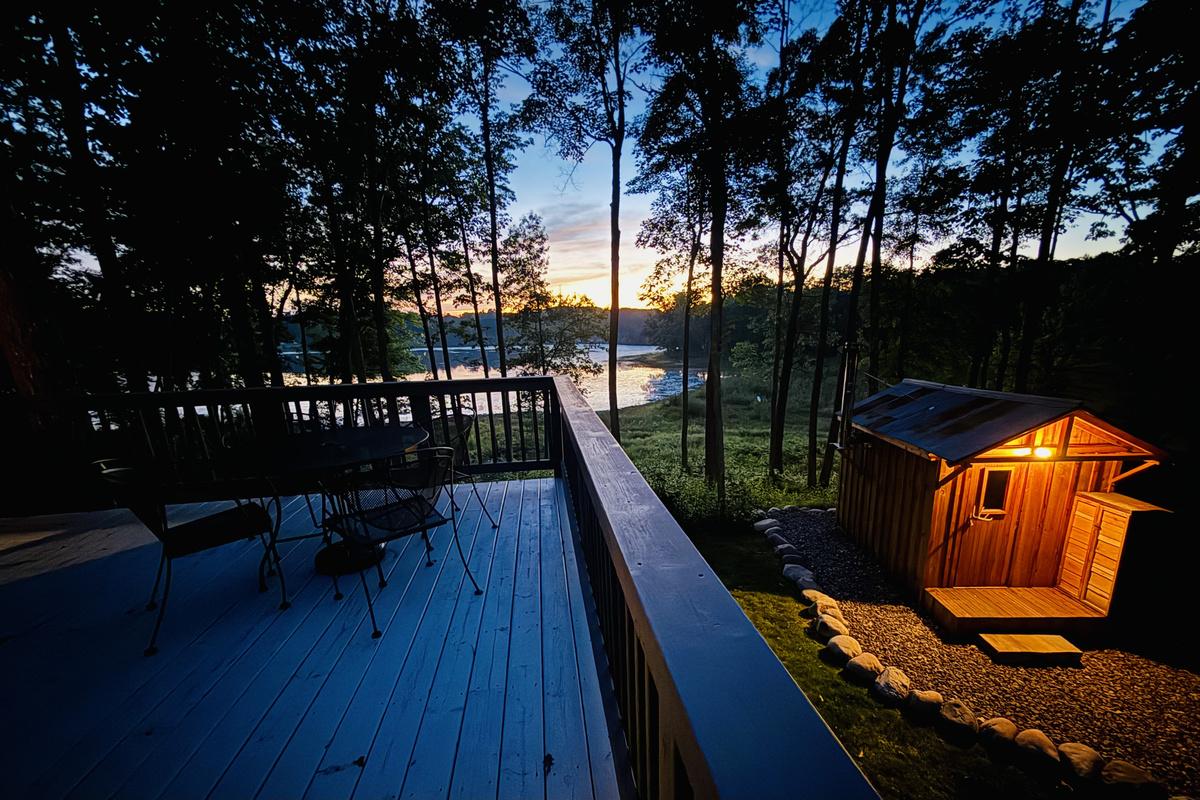 A view of our authentic wood-burning sauna from the deck at dusk.