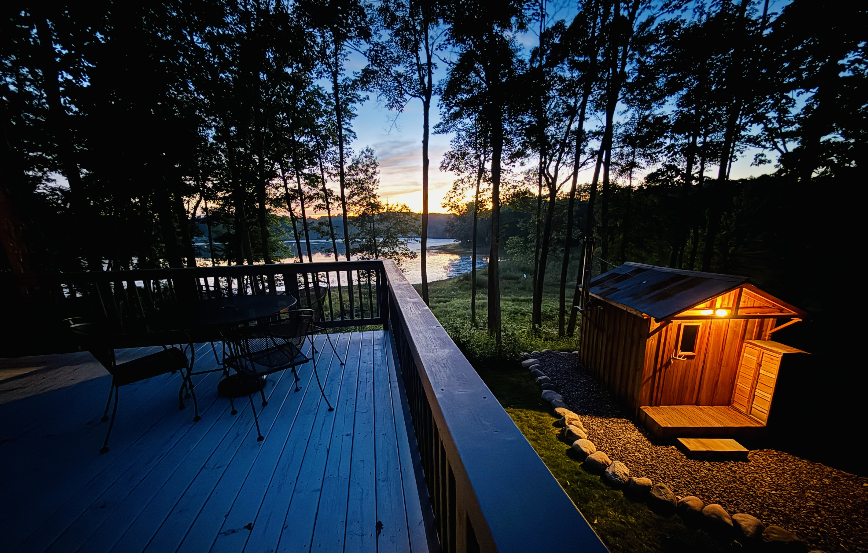 A view of our authentic wood-burning sauna from the deck at dusk.