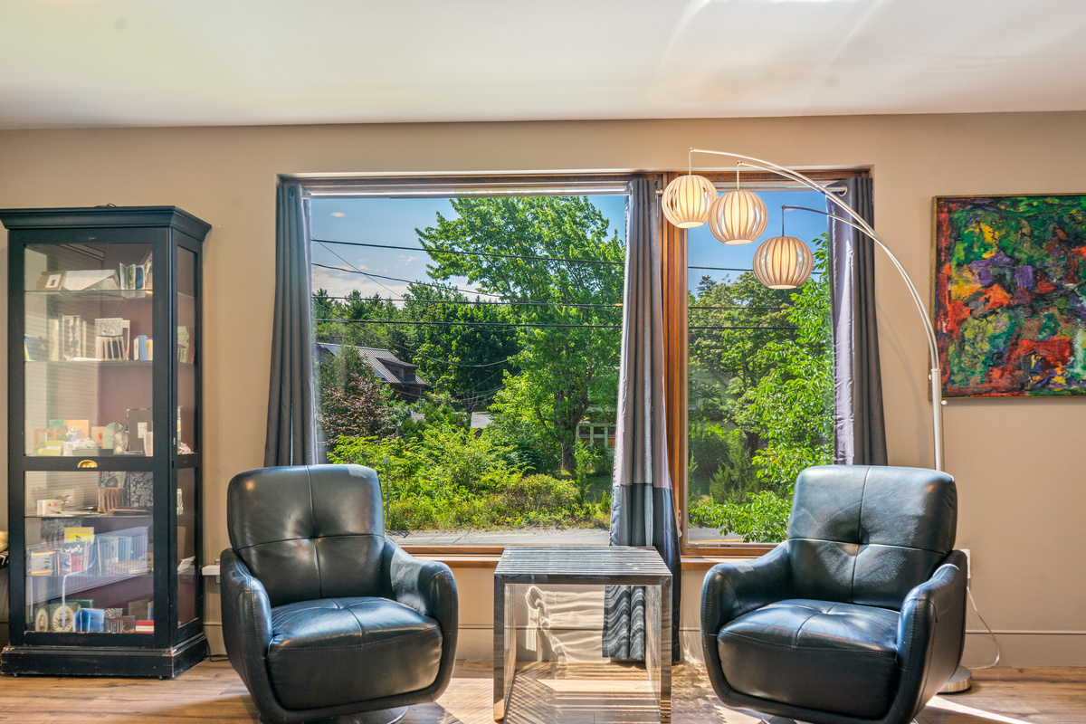 Bright, open landing at the base of the third-floor stairway. This versatile space connects the designer office and the main-level master suite, offering a quiet, sun-drenched area to decompress while overlooking the village of Otter Creek.
