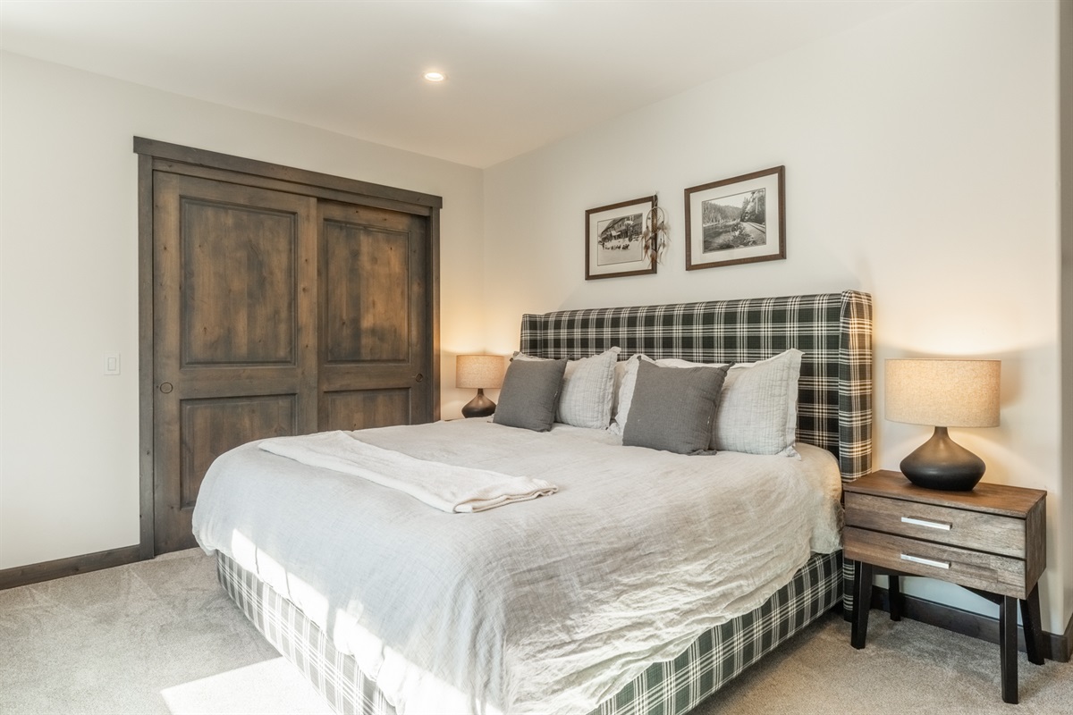 This serene primary bedroom pairs a cozy fireplace, large TV, and en-suite bath with warm finishes and gentle southern light—an easy, inviting space to fully relax and recharge.