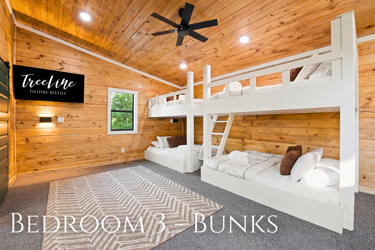 This bunk bedroom provides ample sleeping space with its clean-lined white bunk beds