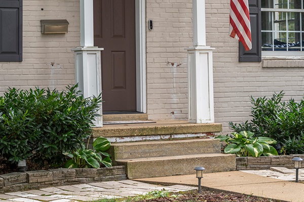 Charming Entrance: Step into this classic home with inviting landscaping and a welcoming flag display!