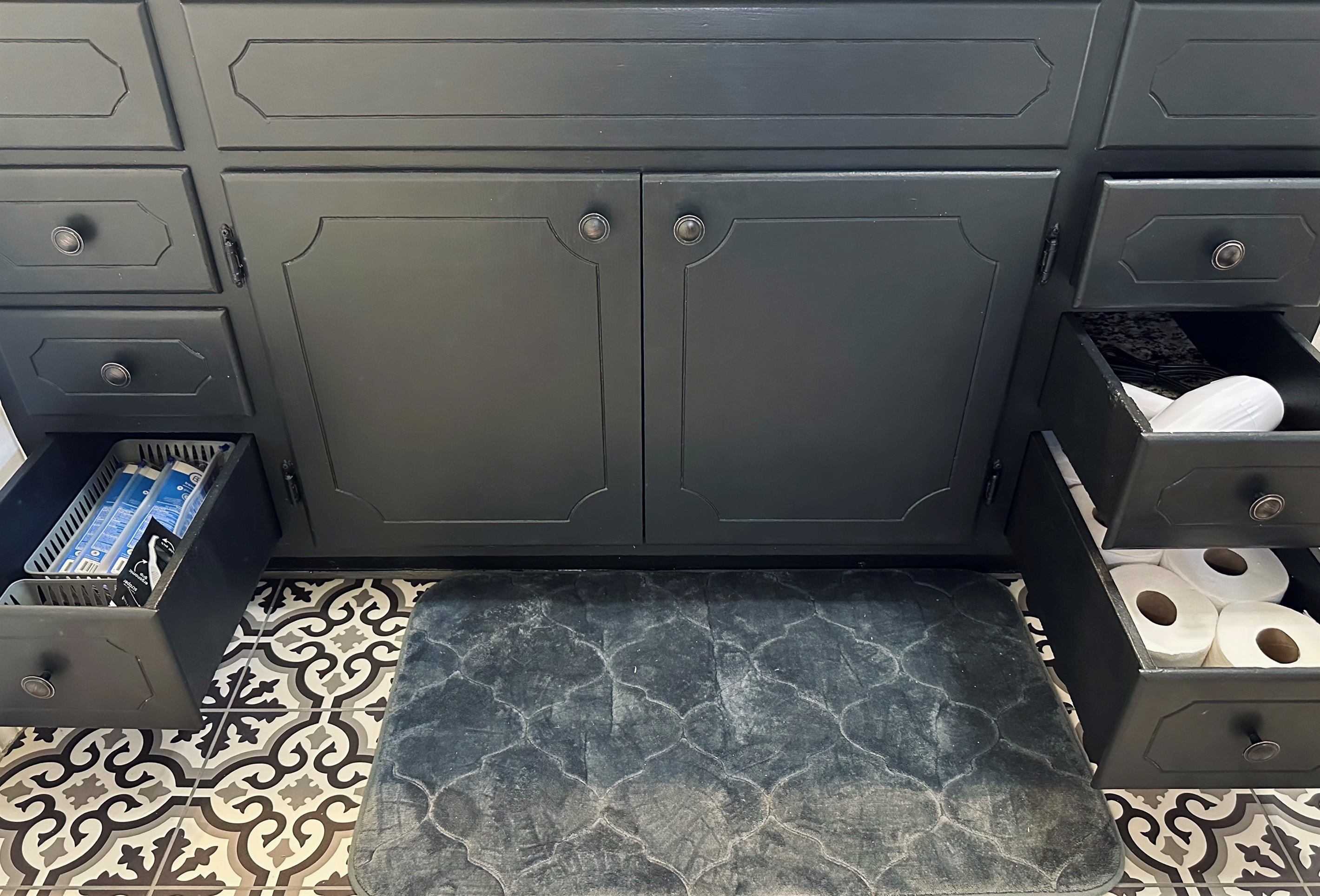 Bathroom drawers thoughtfully stocked with extra toilet paper, a hair dryer and everyday personal care items, including floss picks, toothbrushes, toothpaste, and a lint roller—perfect for quick touch-ups and hassle-free mornings.