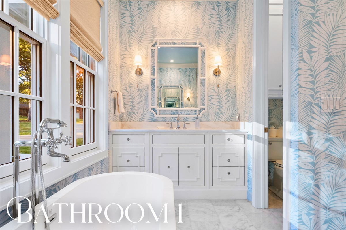 Bathroom with marble finishes and traditional trim detailing.