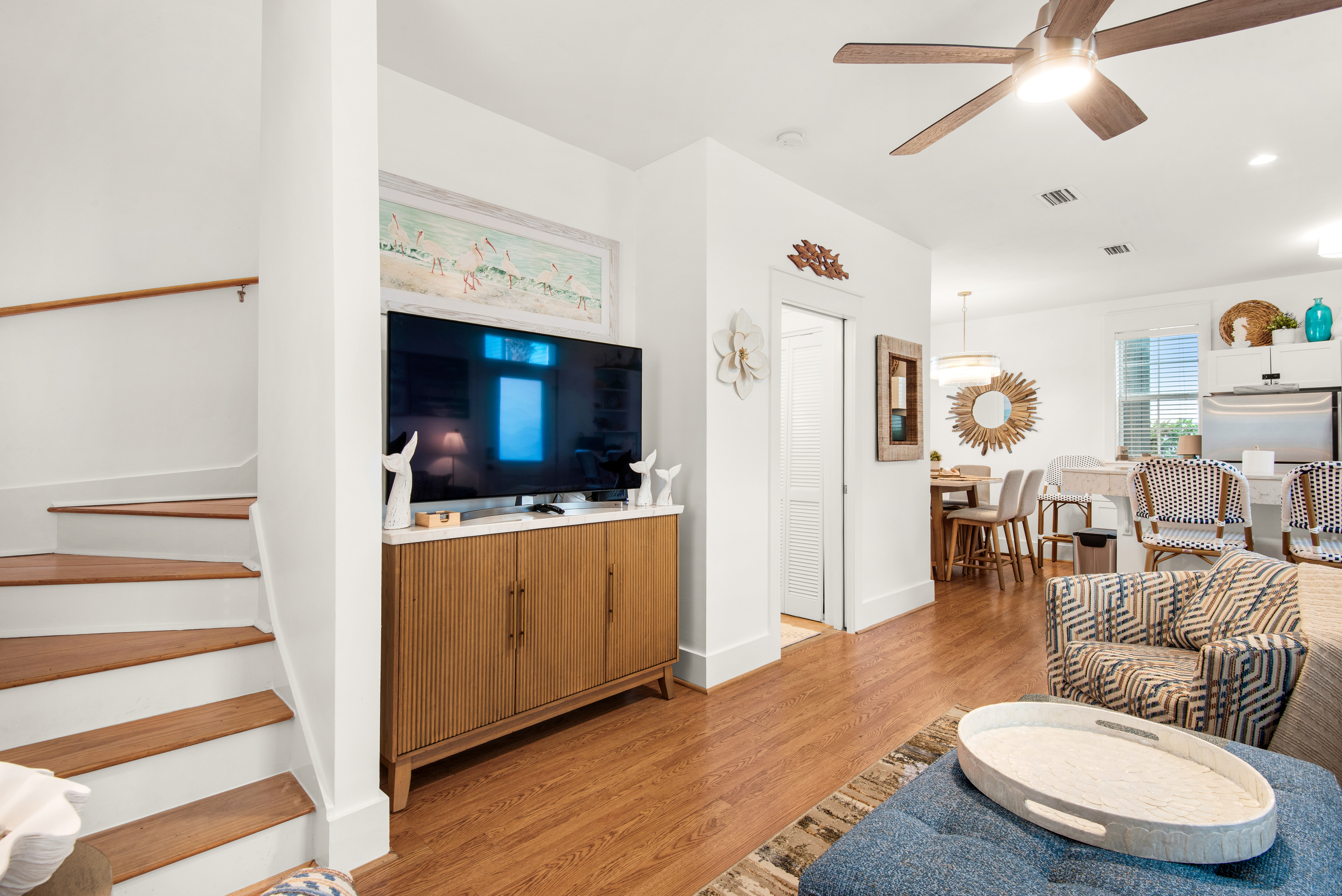 Seagrove Bungalow 103 living area with a television and stairs leading to the upper floor.