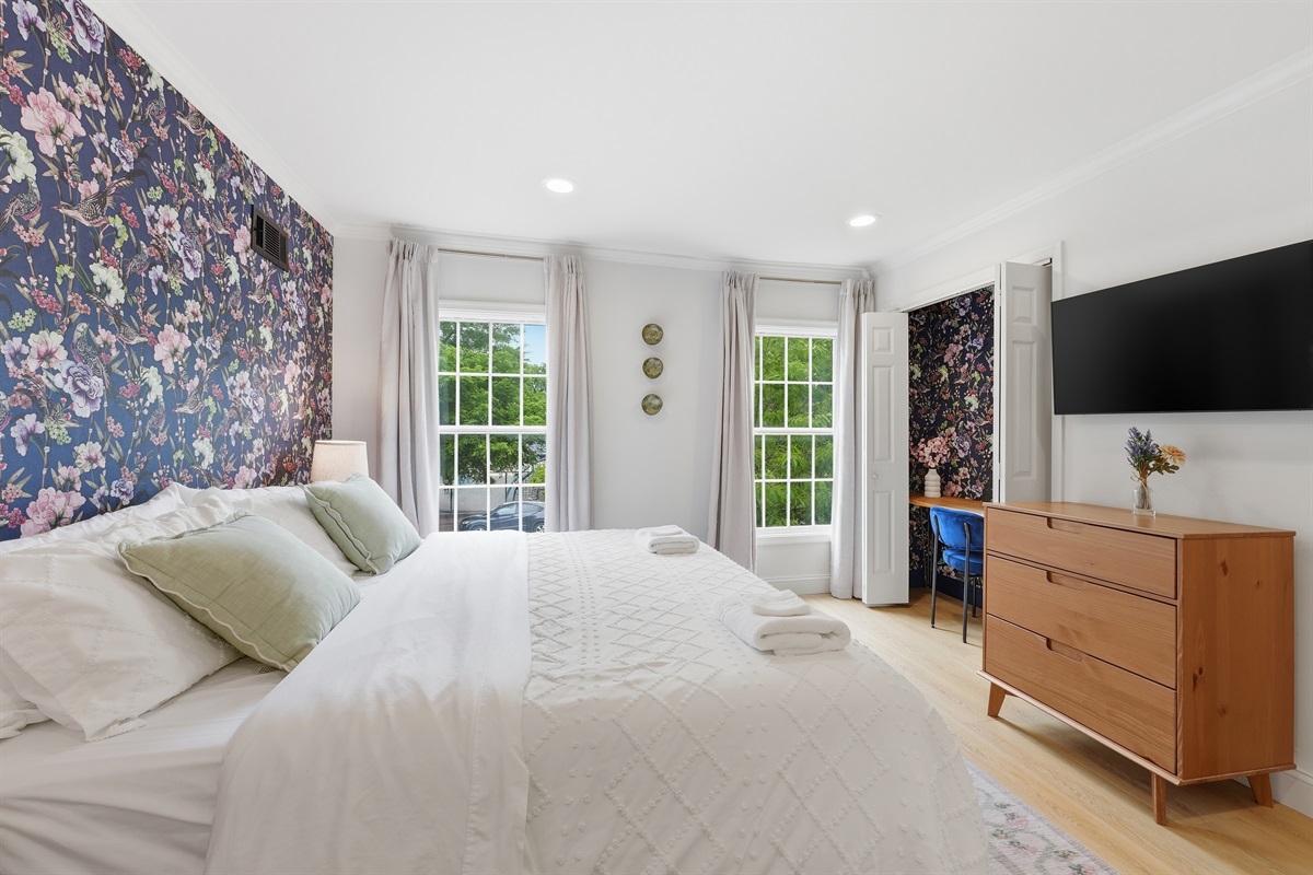 Light-filled king bedroom featuring oversized windows, soft textures, and elegant statement walls for a relaxing stay