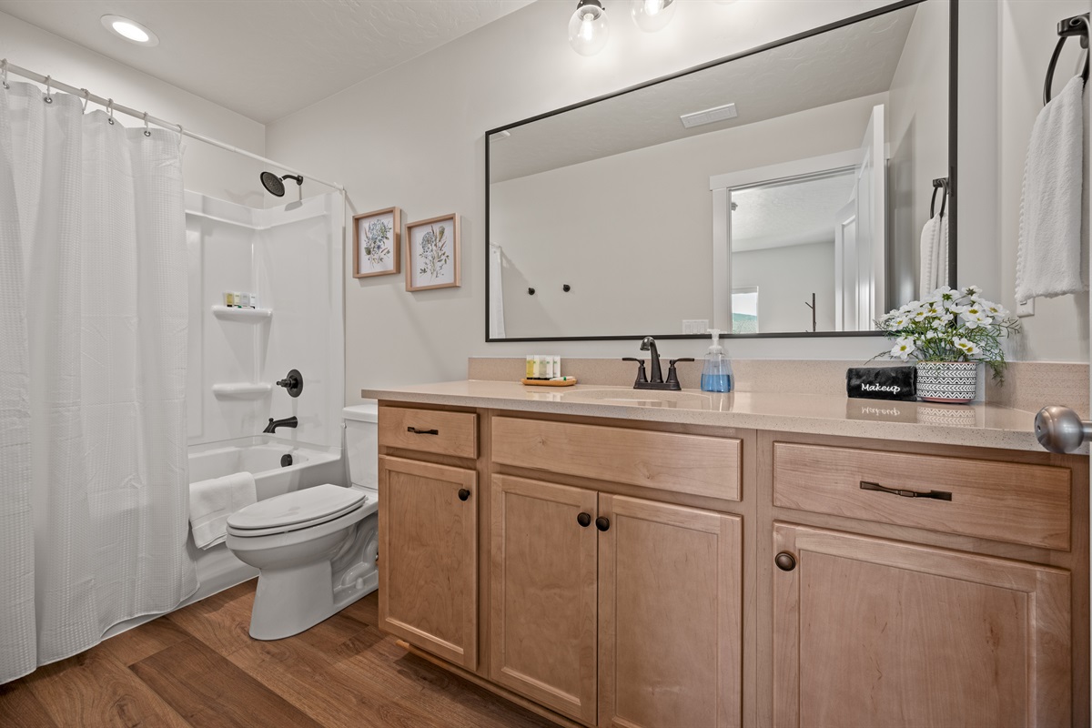 Unwind in this stylish upstairs bathroom featuring a sleek quartz vanity, spacious tub/shower combo, and bright, modern finishes.