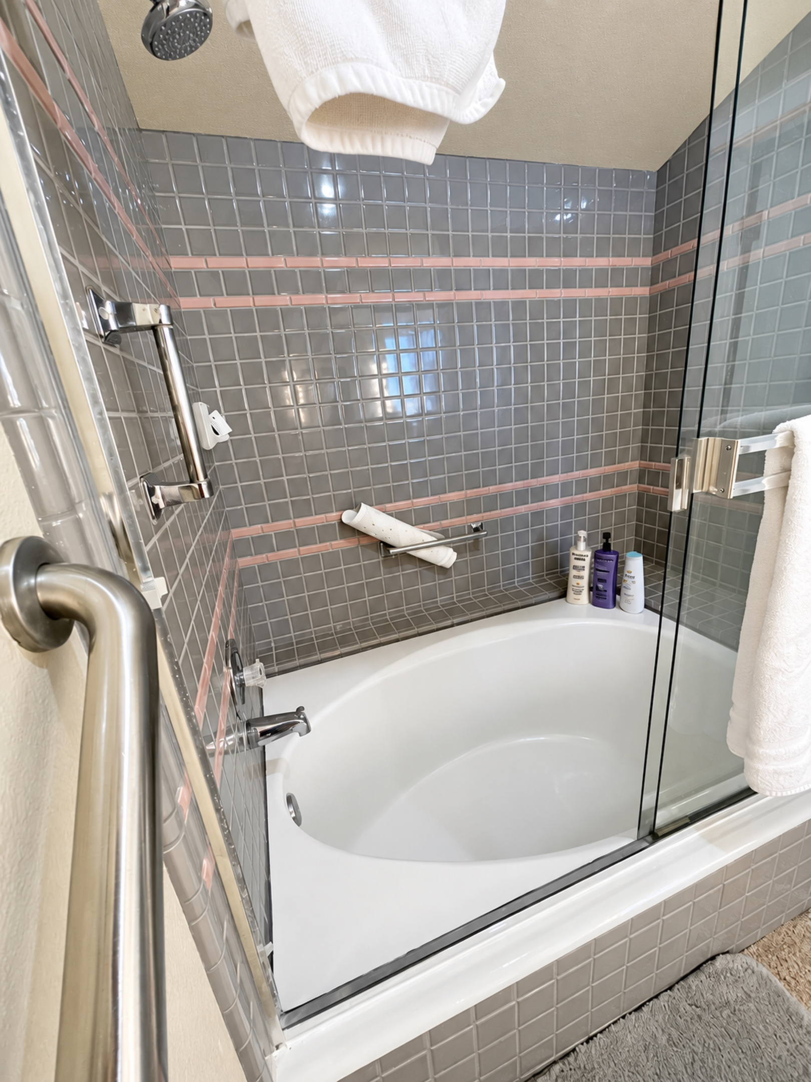 Sunken tub/shower combo with assistance rail; shampoo/conditioner/soap