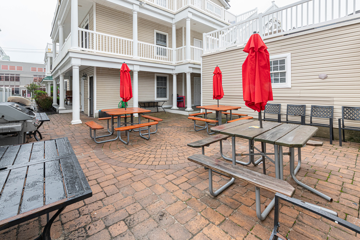 Wide Angle View of Paver Patio, Outdoor Dining Tables, and Building Exterior