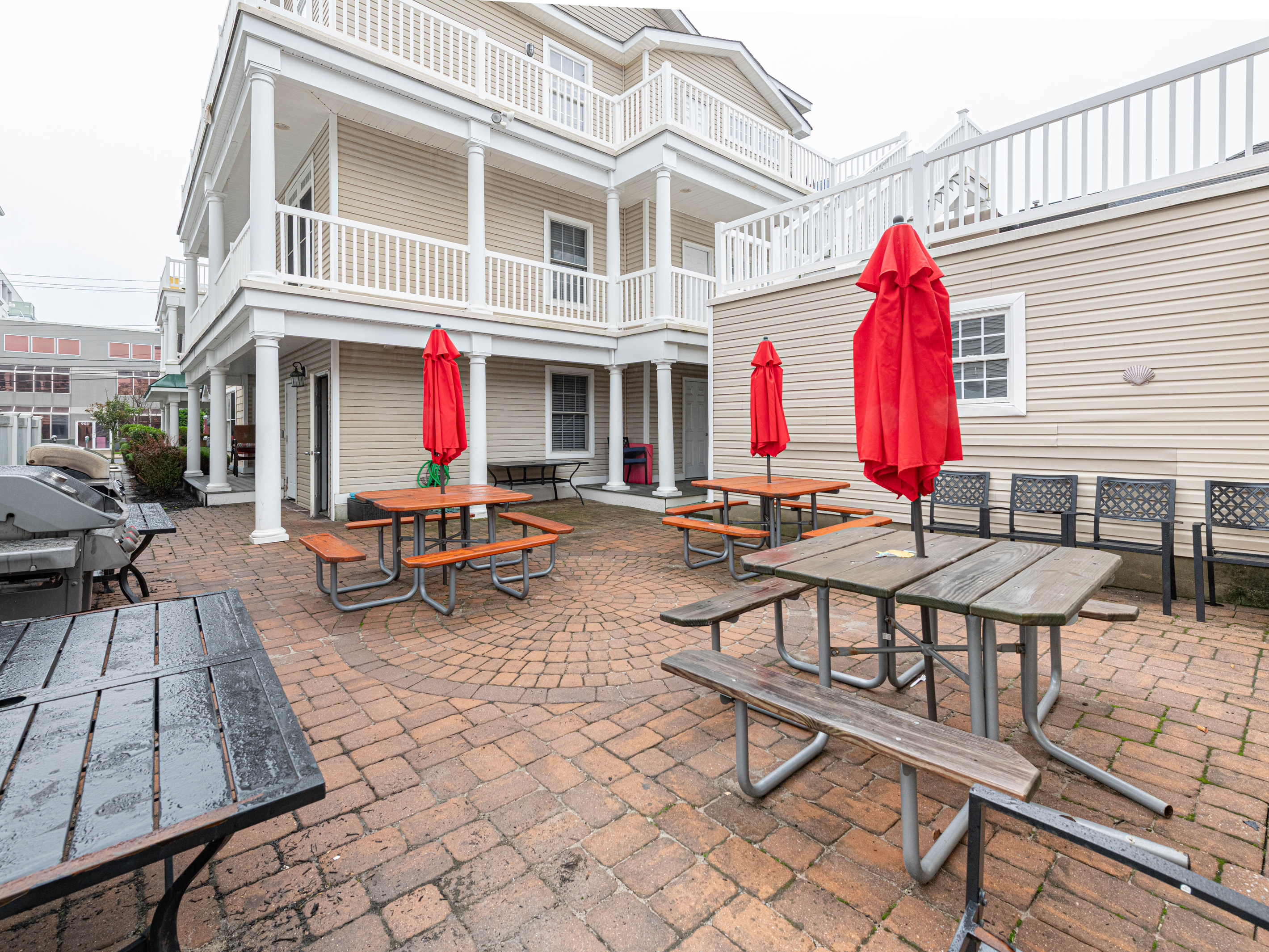 Wide Angle View of Paver Patio, Outdoor Dining Tables, and Building Exterior