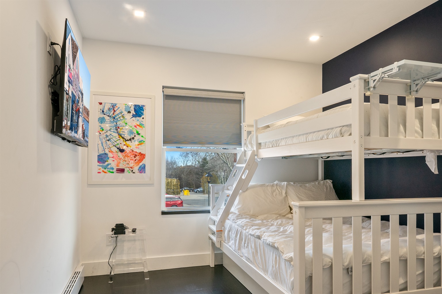 Family-friendly guest room with a Twin-over-Full bunk and a hidden Twin trundle. Includes a 55-inch smart TV, blackout blinds for restful mornings, and high-powered fans. A flexible sleeping space designed for kids or groups in downtown Bar Harbor.