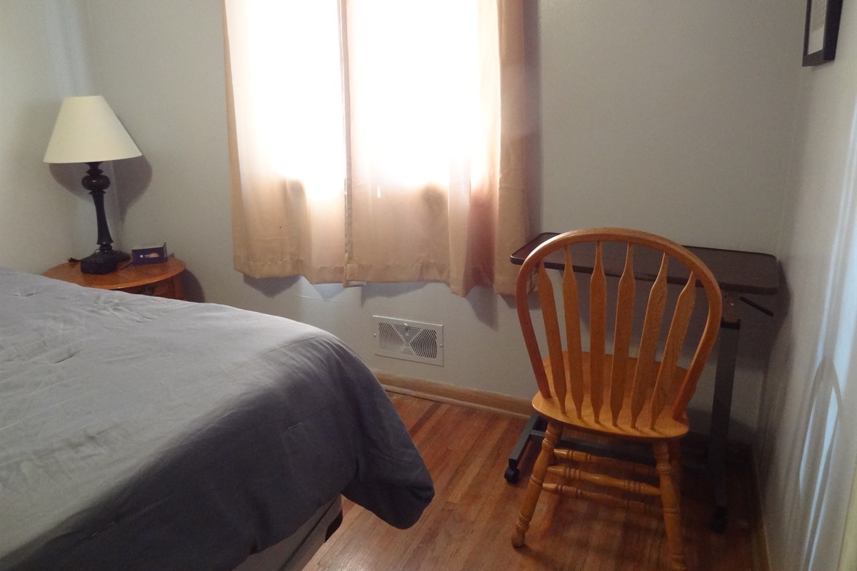 Master bedroom with queen bed, Roku smart TV, dresser, ceiling fan, and desk