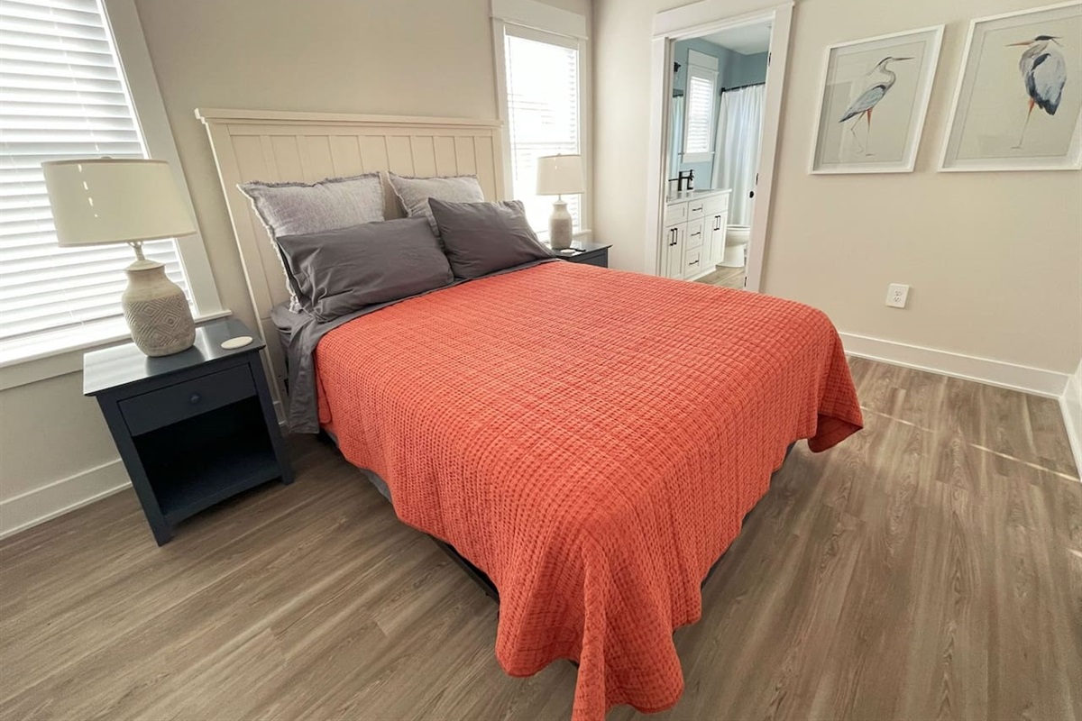 Cozy third bedroom featuring a comfortable queen bed and soft natural light.