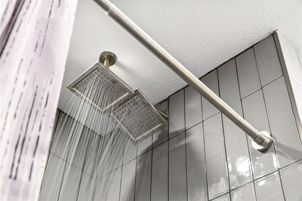A bathroom featuring an overhead shower, providing a soothing and immersive rainfall-like experience for ultimate relaxation.