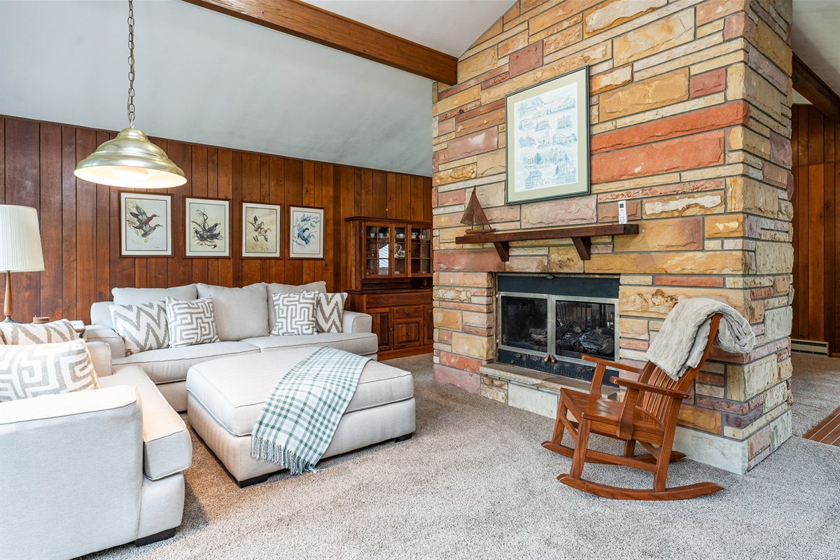 Relax in the bright, airy living room featuring plush seating, sliding doors to the deck, and scenic views of the surrounding greenery.