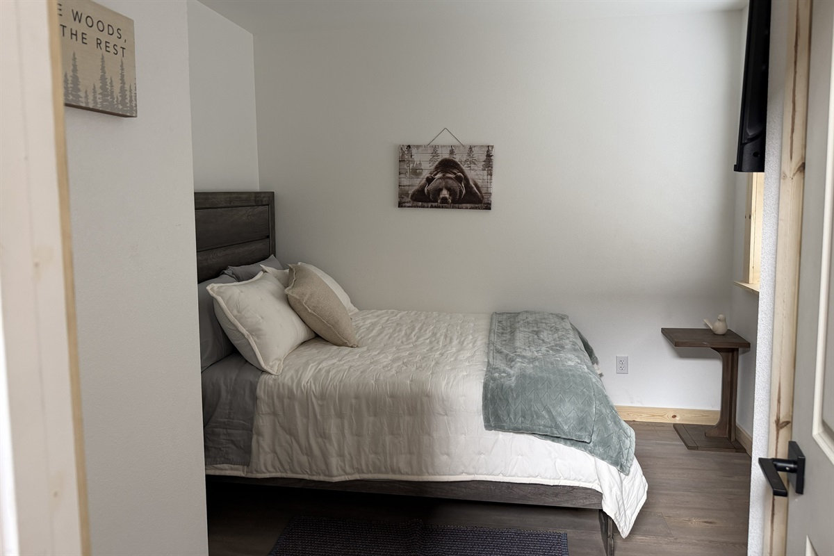 Bedroom on main floor includes a Queen Size Bed with night stand, closet space, and TV.
