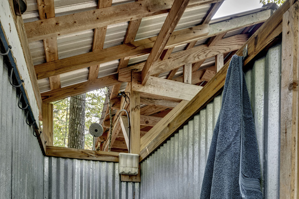 Rustic outdoor shower tucked beneath the trees