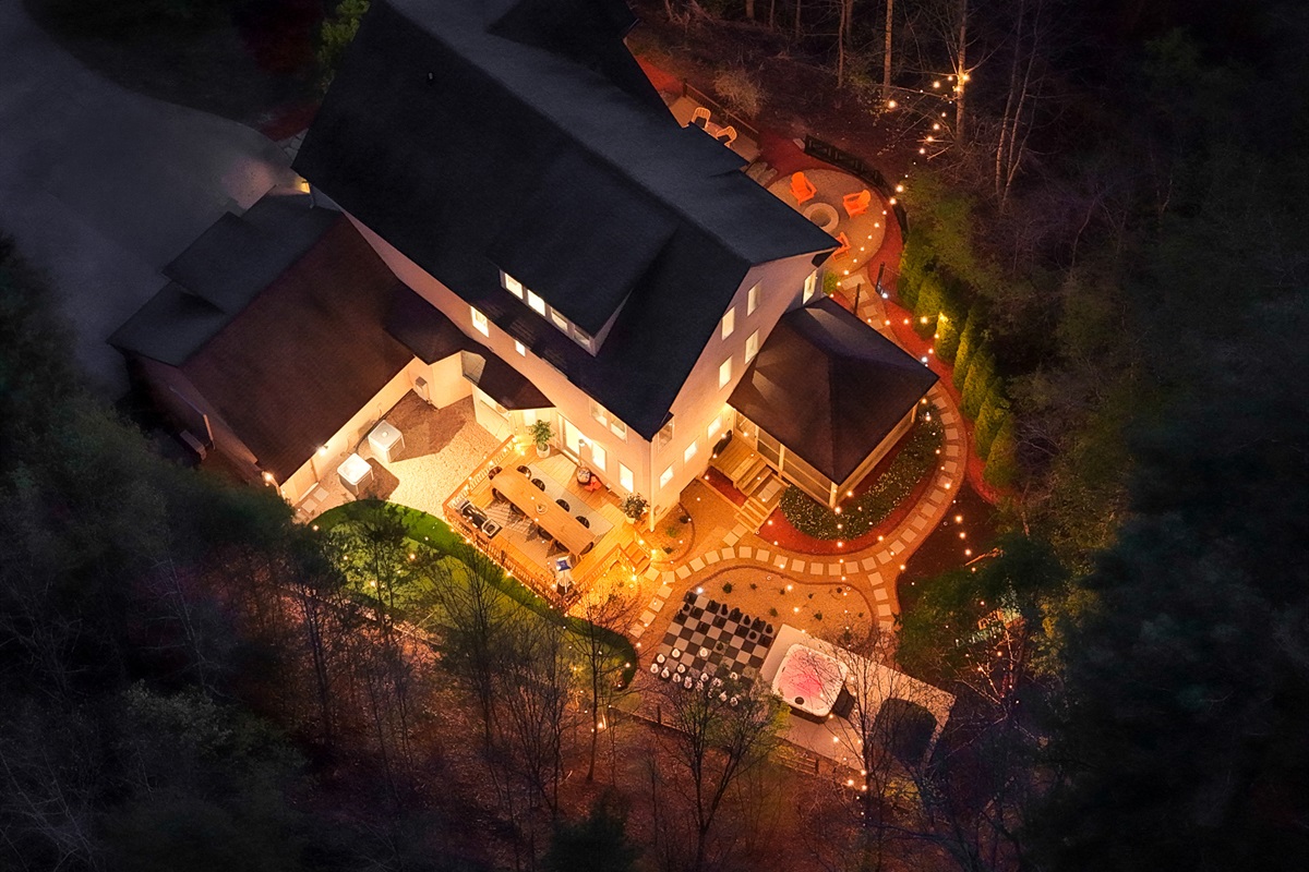 Evening aerial of the property - fully lit and designed for indoor-outdoor living at every hour