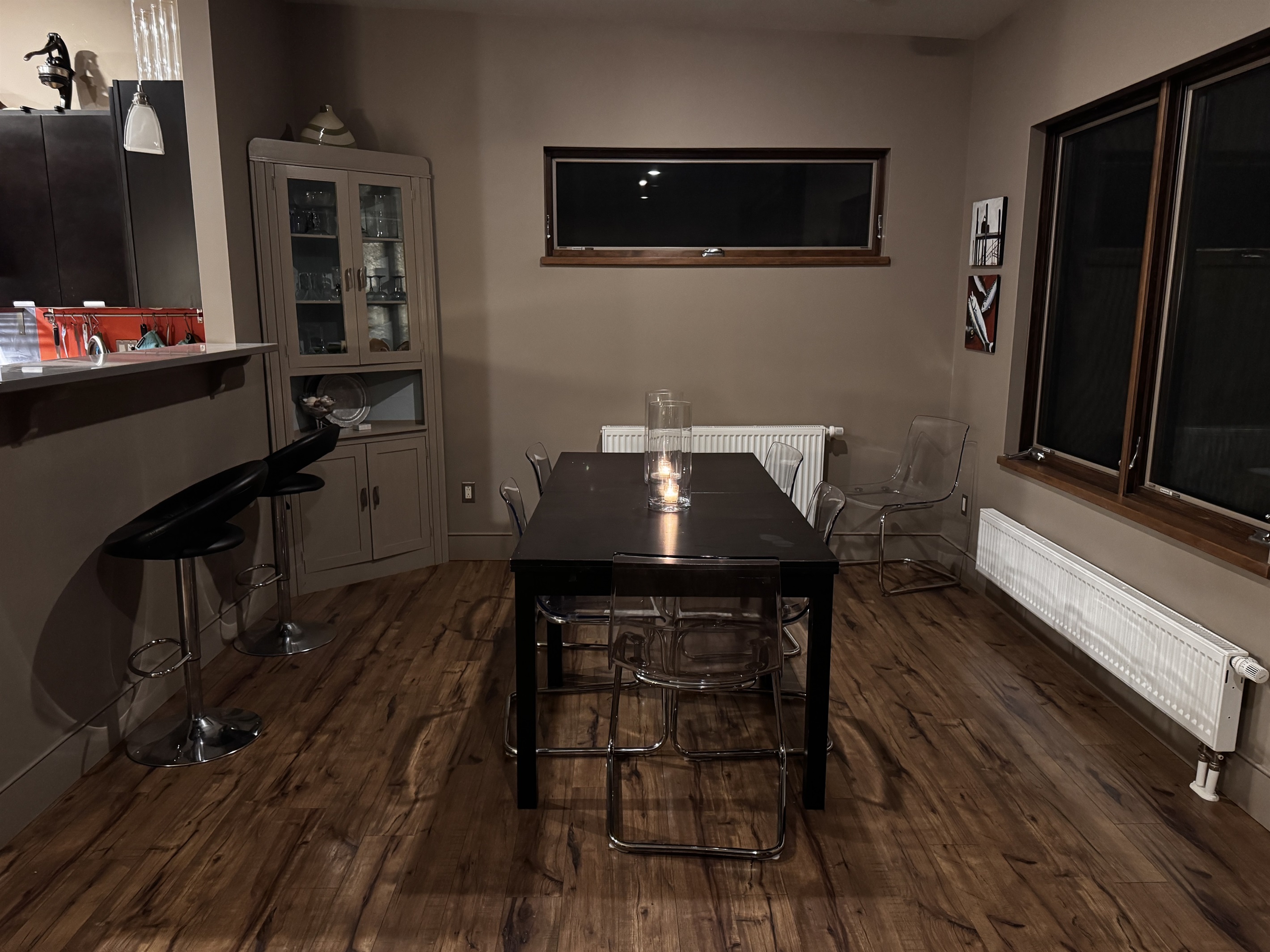 Spacious dining area with seating for six, plus additional breakfast bar seating for two. Large windows overlook the massive backyard, 33ft deck, and fire pit area, perfectly blending indoor dining with the Acadia wilderness outside.