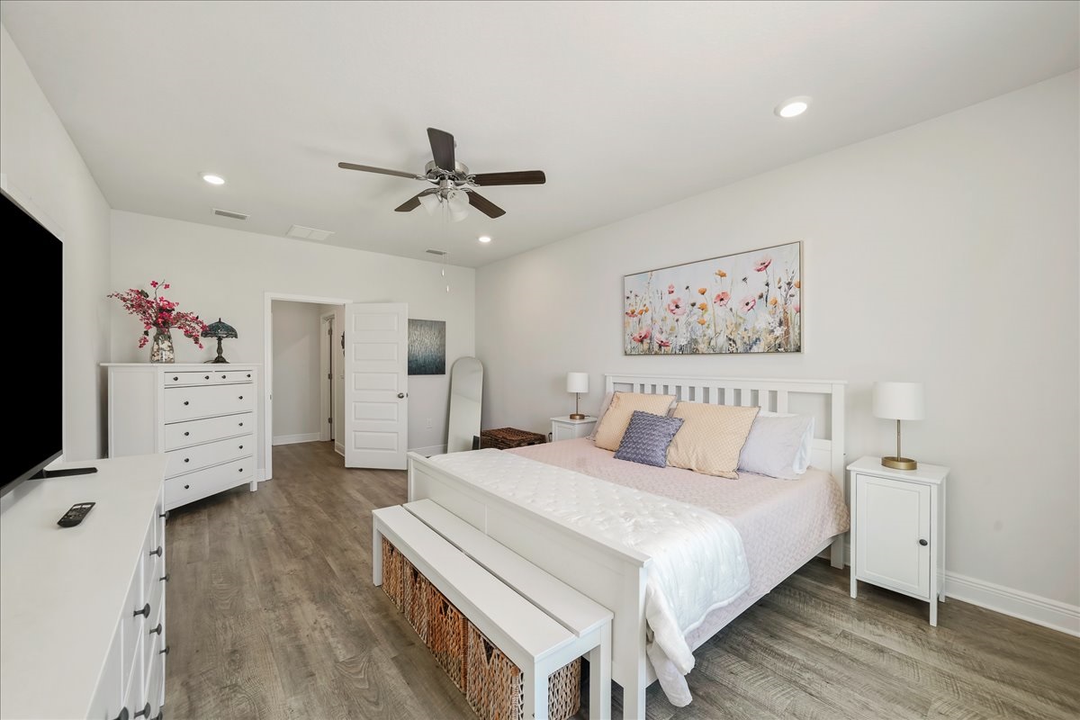 Primary suite: King bed complete with comfortable linens, Smart TV, ceiling fan, and a stylish bench for added convenience.