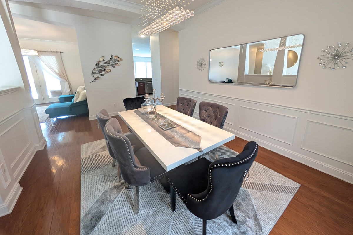 Elegant formal dining room with seating for six and a statement chandelier overhead.