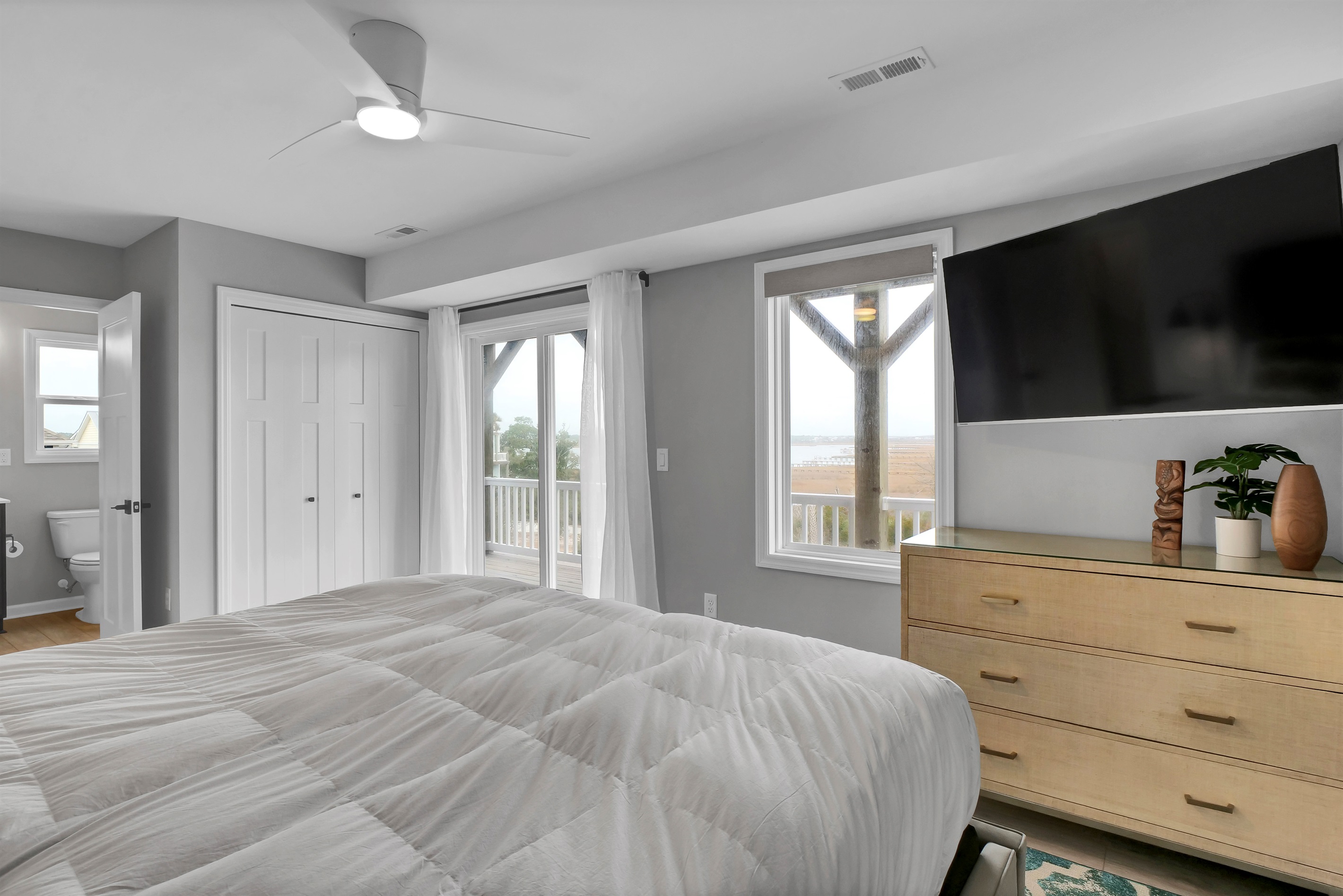 This modern bedroom offers TV for entertainment, ceiling fan for comfort, and generous closet and dresser storage
