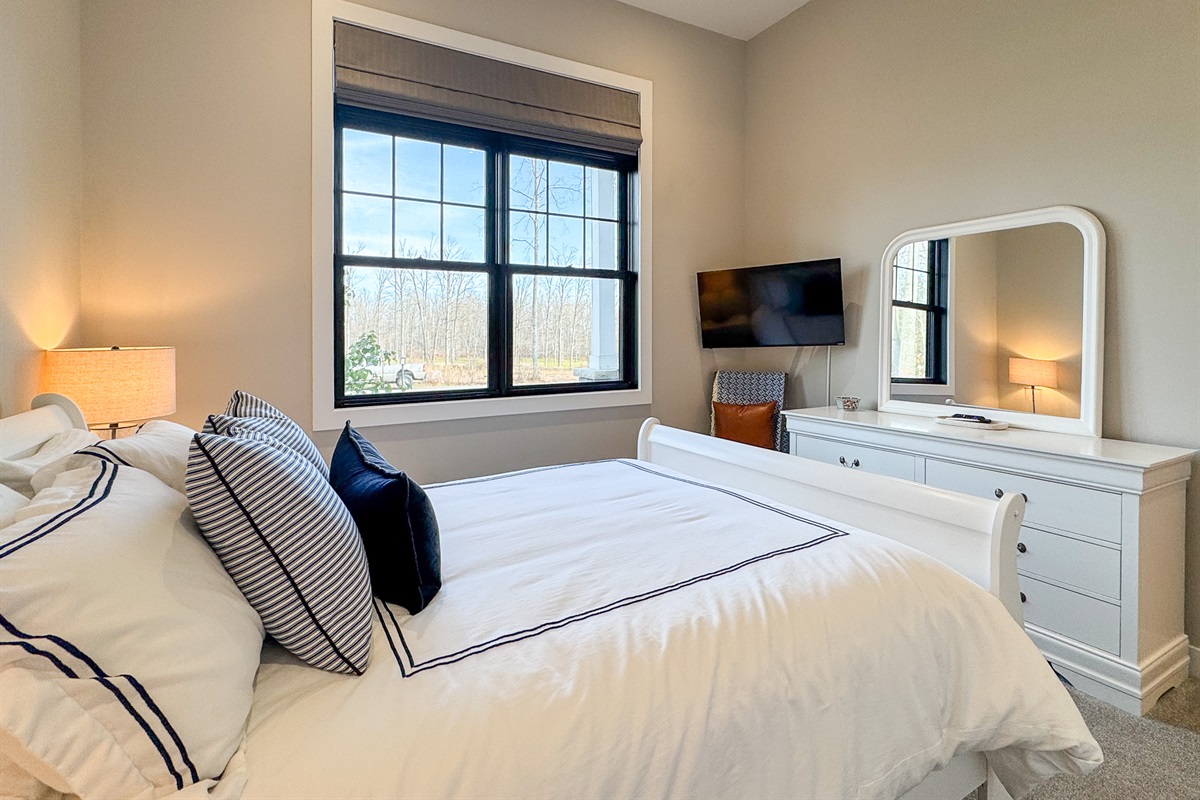 Guest bedroom with queen bed and tv with streaming.